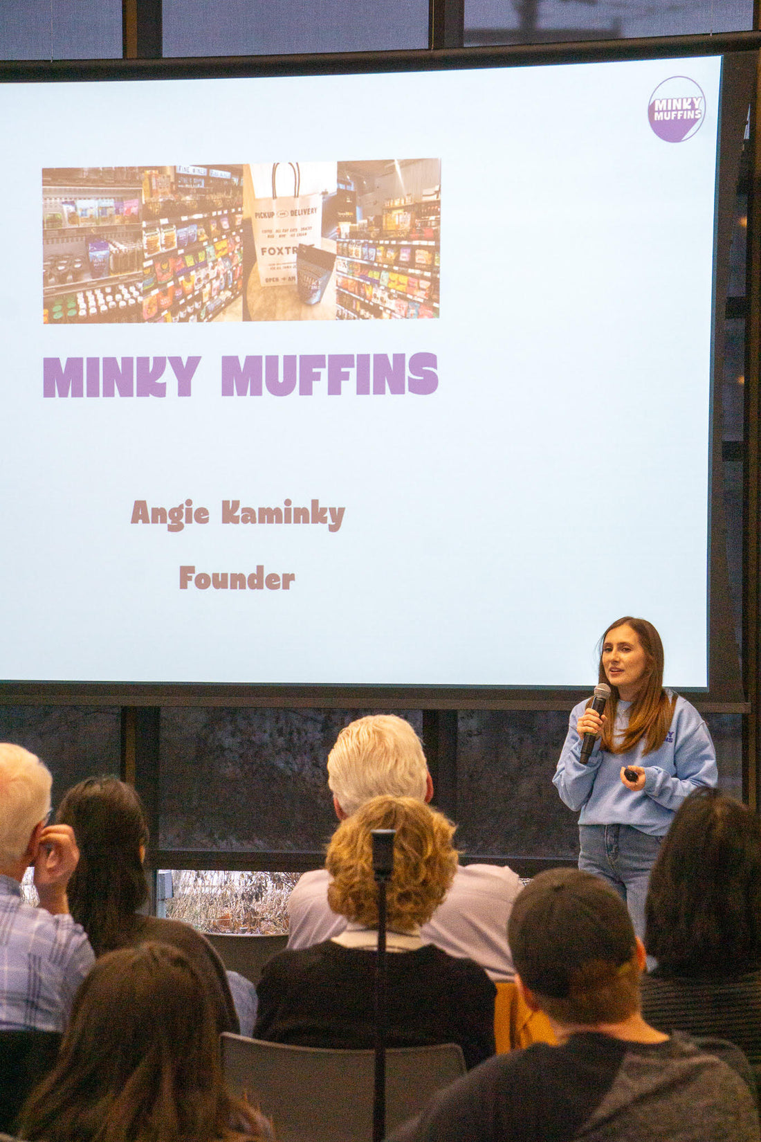 Minky Muffins' founder delivering a presentation on Minky Muffins to a crowd of people.