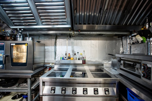 Commercial kitchen space with industrial grade equipment and appliances.