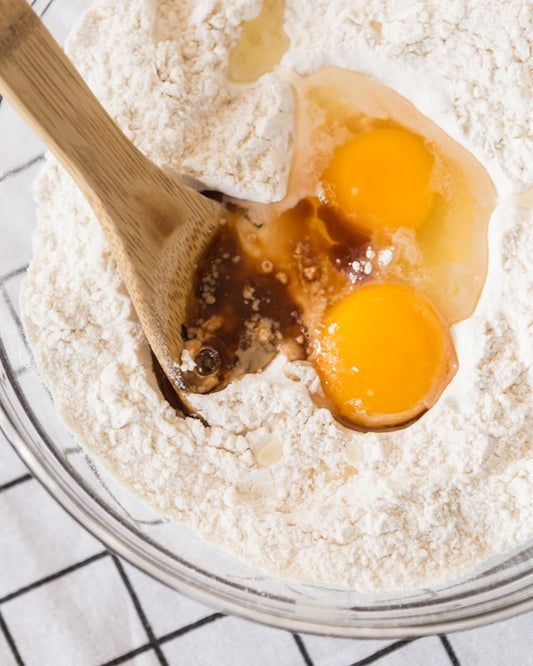 Flour and eggs in a mixing bowl to prep for baking.