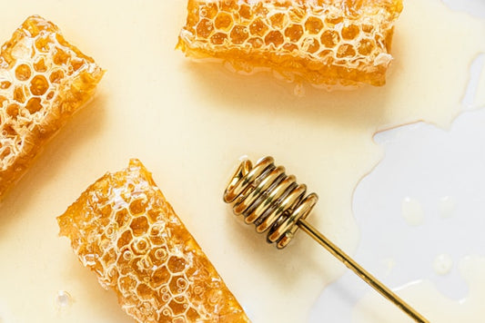 honeycombs with honey on them and a honey dipper, which is commonly used as a honey spoon)